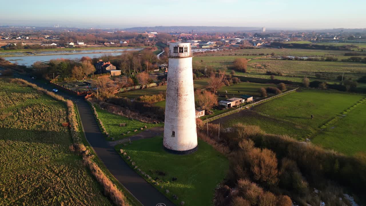 Beautiful aerial drone anti-clockwise pan and move in close of Leasowe Lighthouse at sunset in winter, UK
