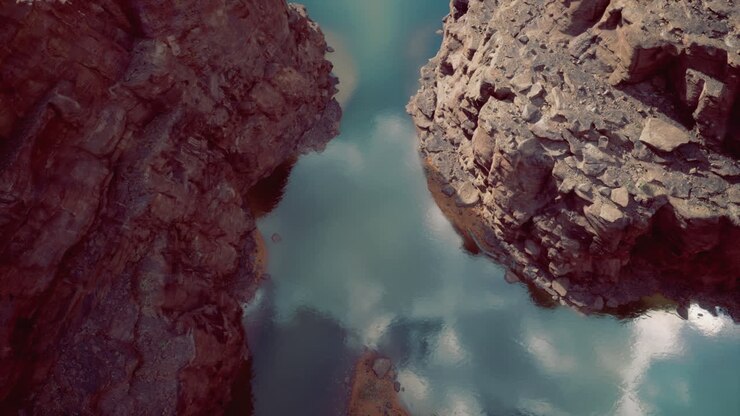 Riflesso sereno dell'acqua tra scogliere rocciose in un canyon remoto.