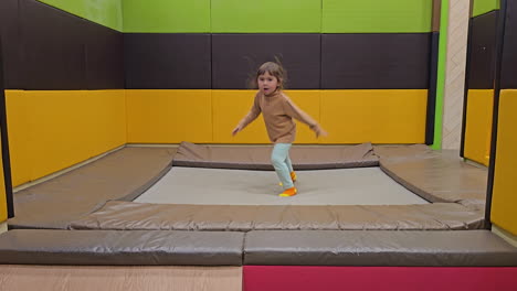 active child girl jumps on a trampoline alone