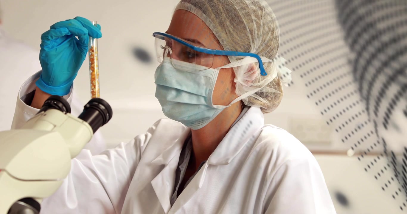 Video vertical: Levantando un tubo, un técnico con EPP alineando y revisando una muestra en el microscopio mientras pasan puntos.