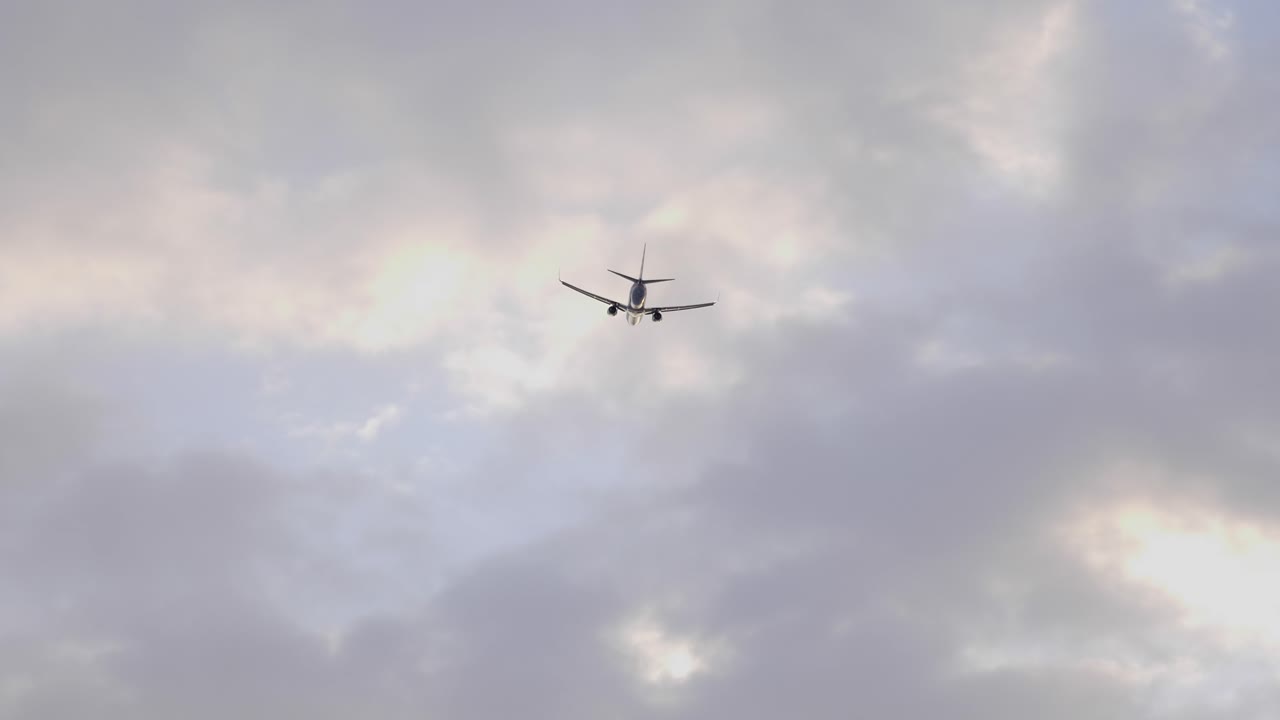 Fly flyver på himlen mod den overskyede himmel