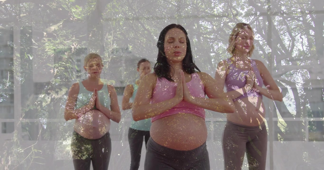 Gravide kvinner følger instruktør som veileder pusting på matter i prenatal yoga i solfylt studio