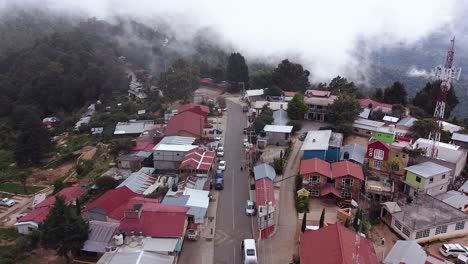 vuelo de avión no tripulado sobre un pueblo rural en el bosque de montaña con niebla que se levanta, oaxaca, méxico