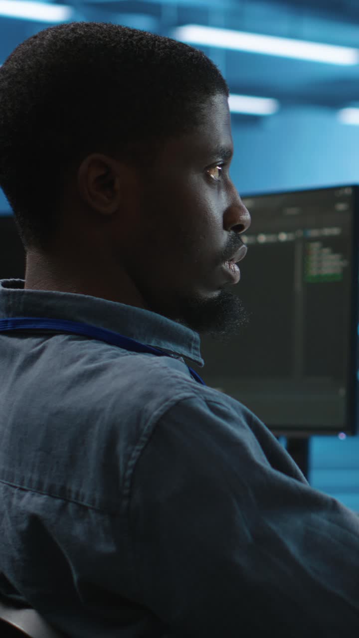 Focused Programmer Working on Computer in Dark Server Room