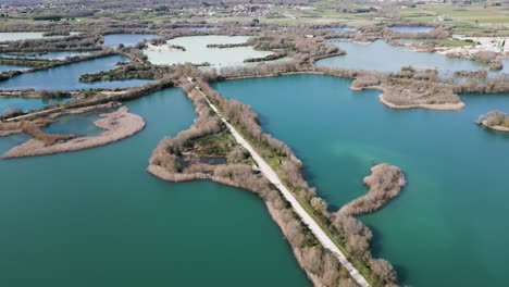 Aerial-pullback-above-open-winding-body-of-water-with-pathway-across-reeds-at-ancient-Antela-lagoon-Areeiras-da-Limia-in-Xinzo-de-Limia-Ourense-Galicia-Spain