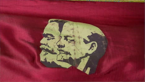 close up of a stylized depiction of karl marx and vladimir lenin on a soviet parade flag