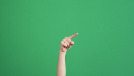 niño con la mano contando algo o señalando a alguien o algo sobre el fondo de la pantalla verde clave de croma.