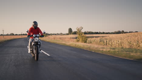 a young man rides a motorbike along corn fields 4