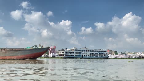 Schwenk-Entlang-Des-Geschäftigen-Flusshafens-In-Dhaka-Mit-Vorbeifahrenden-Frachtschiffen