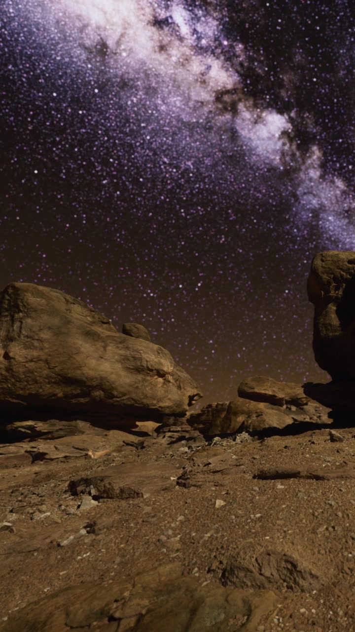 La Vía Láctea brilla sobre un paisaje rocoso de noche en un lugar desértico