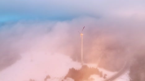 Clouds-moving-past-a-windmill-standing-tall-on-a-mountain