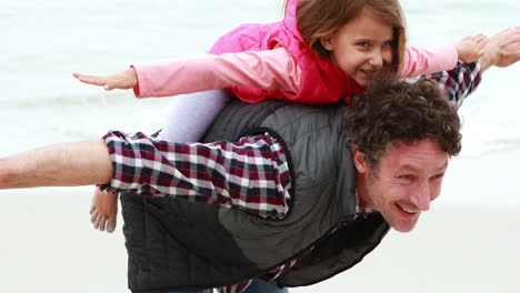 father giving piggy back to daughter