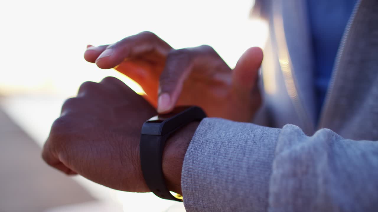 hombre afroamericano haciendo ejercicio al aire libre usando un reloj inteligente