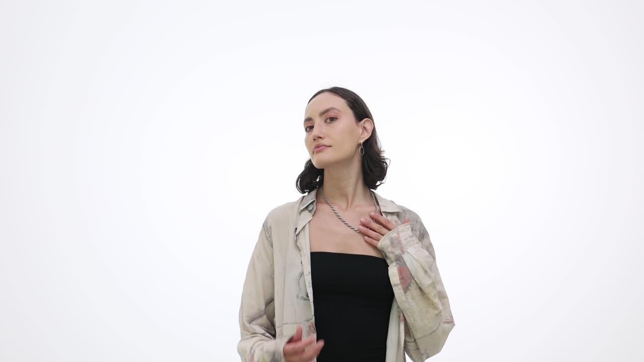 Giovane donna elegante che posa su sfondo bianco