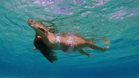 Little-red-hair-girl-relaxes-by-floating-with-open-arms-and-letting-herself-be-lulled-by-ocean-movement