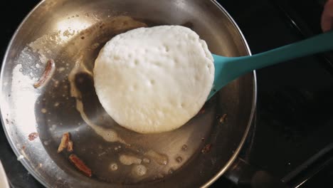 Canada---Flipping-Pancake-Cooked-In-A-Stainless-Pan-With-Melted-Butter---Closeup-Shot