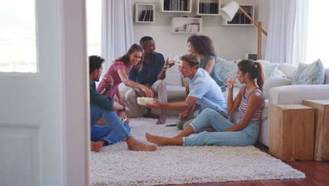 group of friends relaxing at home and drinking wine together