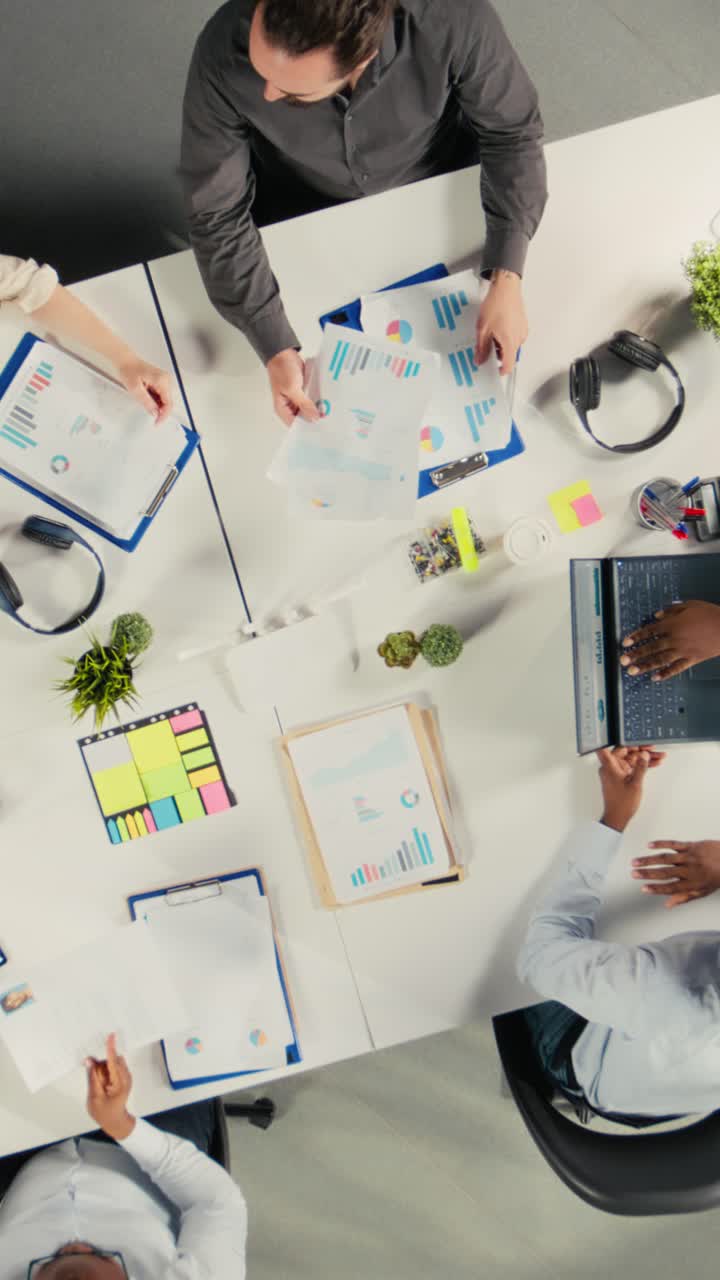 Vertical Video Top down view zoom out of business staff gathered for briefing