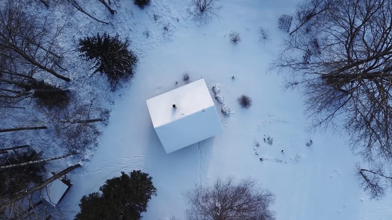 숲 한가운데 있는 작은 집의 하얀 눈 덮인 지붕