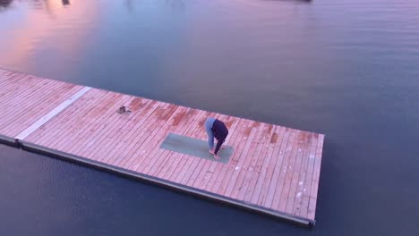 aerial view of a woman doing yoga on a dock