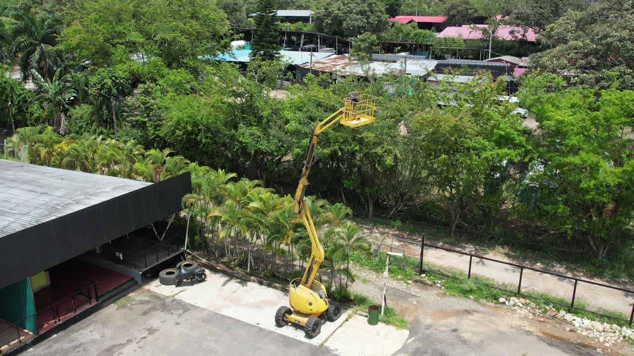 Aerial drone orbit of a construction lift platform in action. Circular motion around industrial machinery at a building site. Ideal for construction, industry, and technology themes.