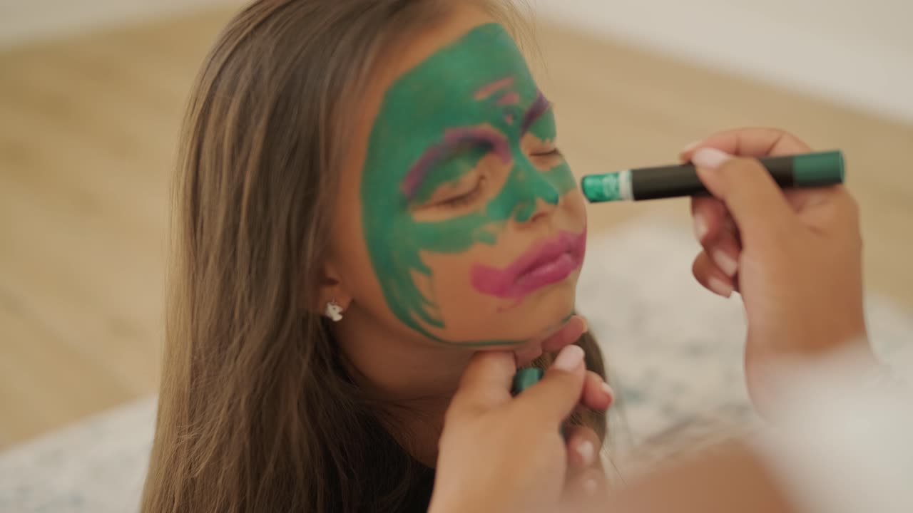 niña pequeña pintando la cara para halloween