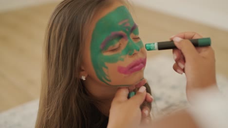 little girl getting face painted for halloween