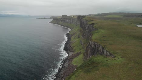 drone shot of coast cliffs in isle of skye scotland, green landscape and calm sea