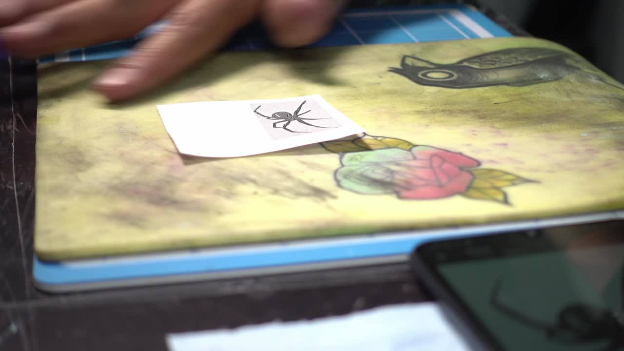 un artista del tatuaje limpiando piel sintética para dibujar un tatuaje