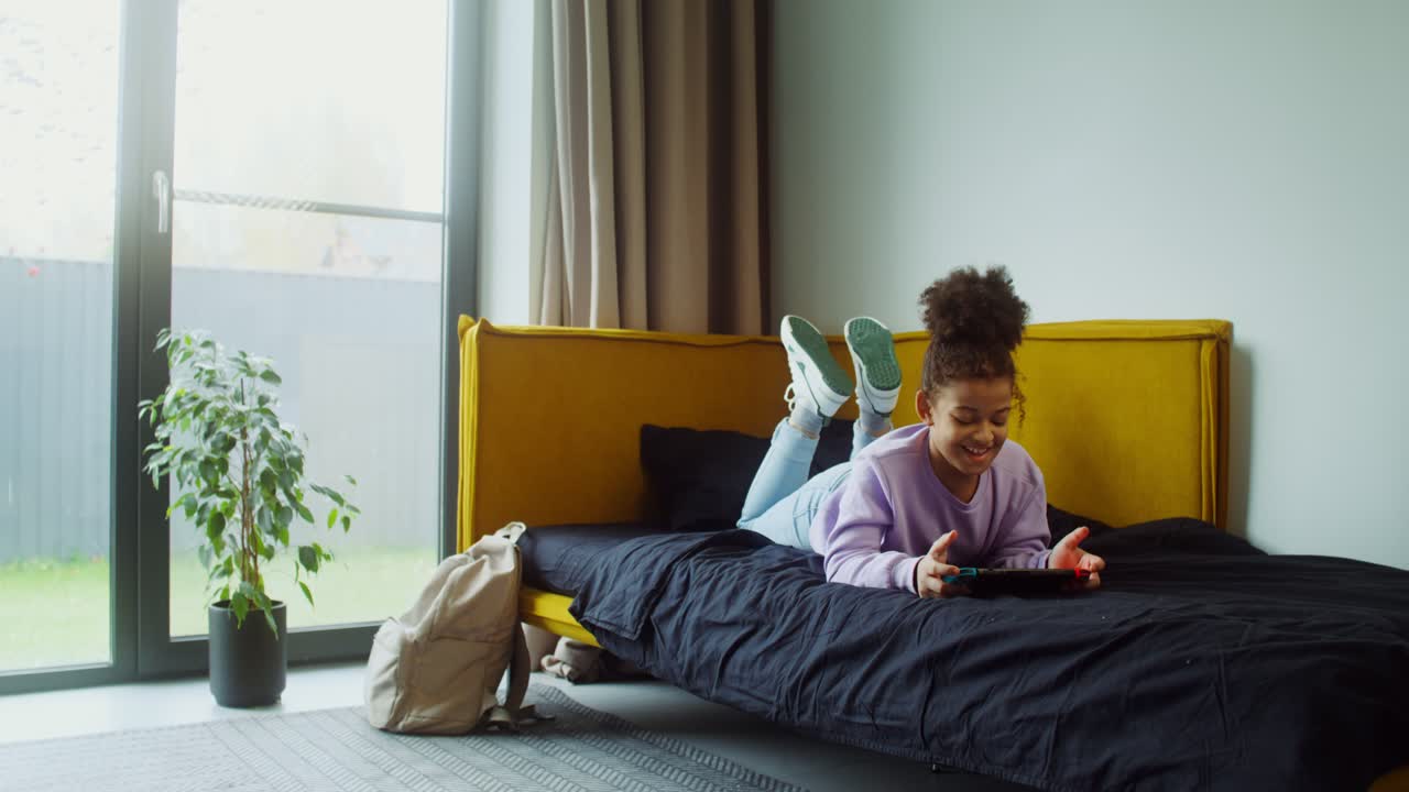 Teenager playing video game on bed