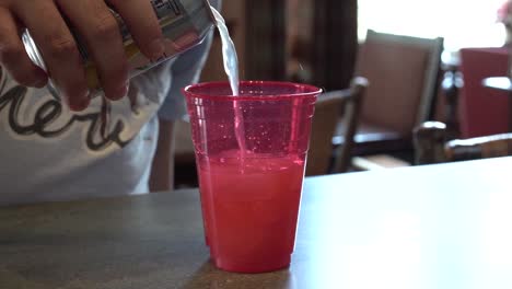 man pouring a can of soda