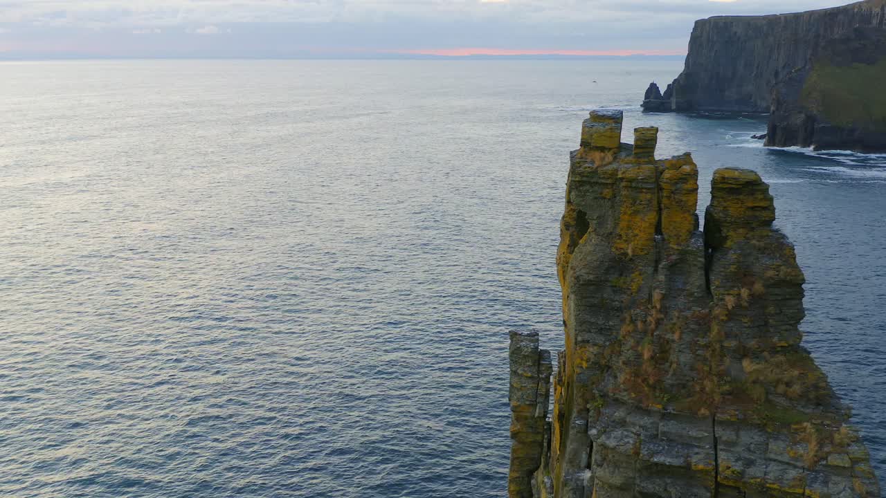 panorámica aérea de la icónica pila de mar en los acantilados de moher durante la puesta de sol, mostrando una escena vibrante