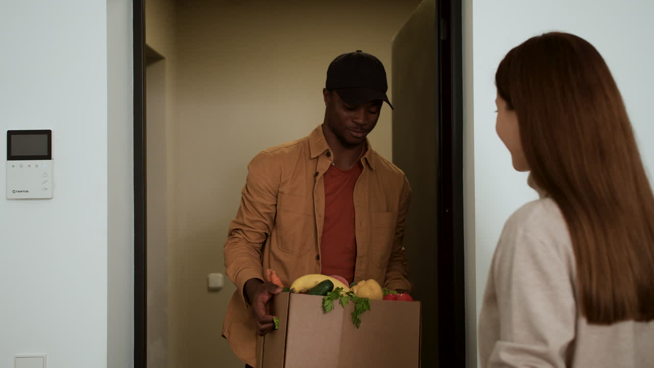 mujer recibiendo una caja de verduras