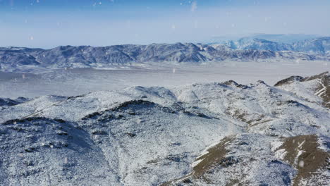 hermoso valle rocoso cubierto de nieve durante las nevadas, vista aérea de regreso