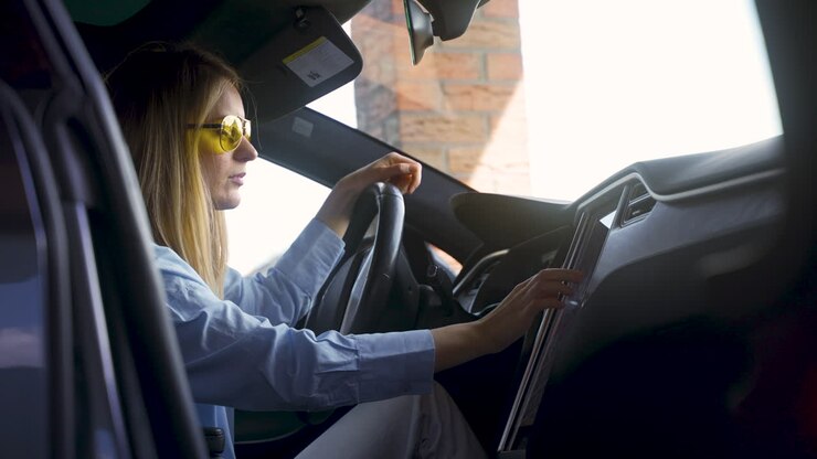Donna bionda seduta su un'auto elettrica