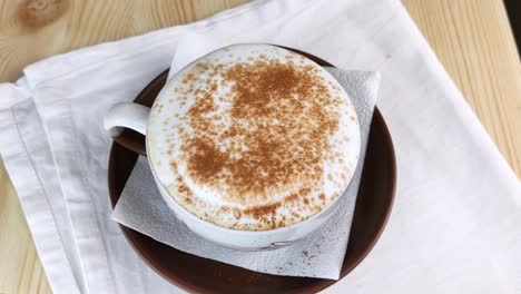 Cappuccino or latte. Spoon scoops milk froth from cup of coffee