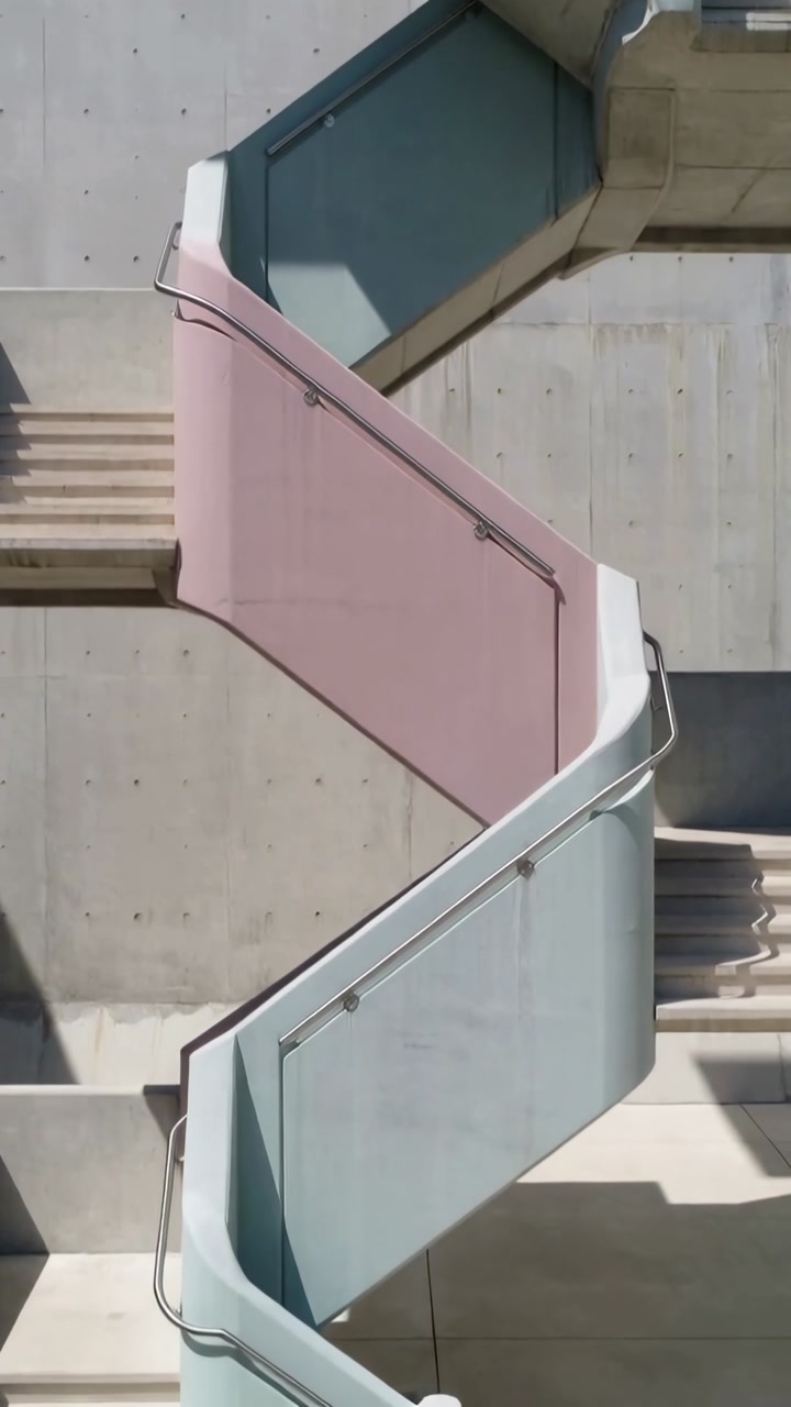 Vertical video: Panning camera revealing zigzag stairs, pastel panels on concrete casting shadow