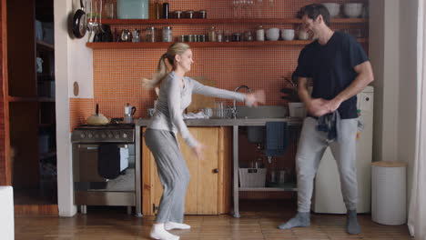 happy couple playing in kitchen washing dishes throwing soap bubbles having fun enjoying relaxing weekend together at home