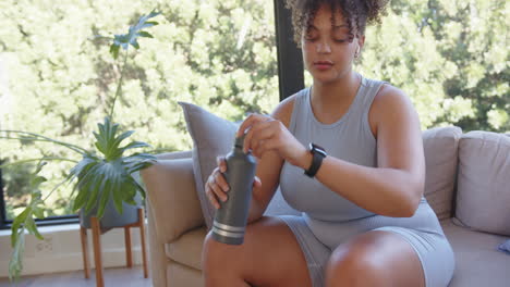 drinking water and resting, plus size woman in workout clothes after exercise