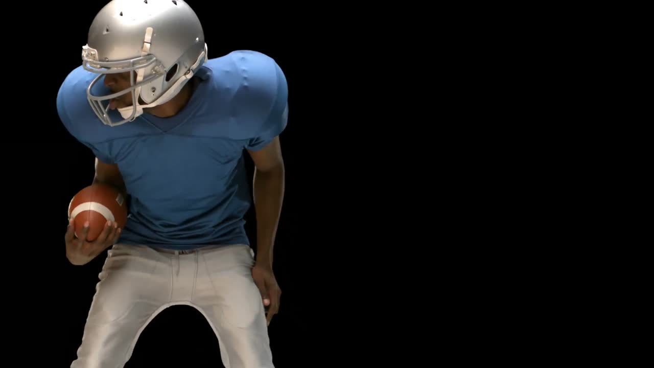 Giocatore di football americano serio che placa per il pallone