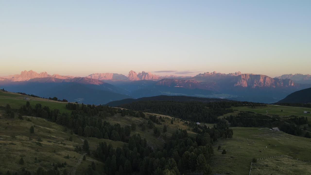 ripresa aerea con drone delle alpi durante il tramonto con capanne e terreni agricoli, bellissima natura