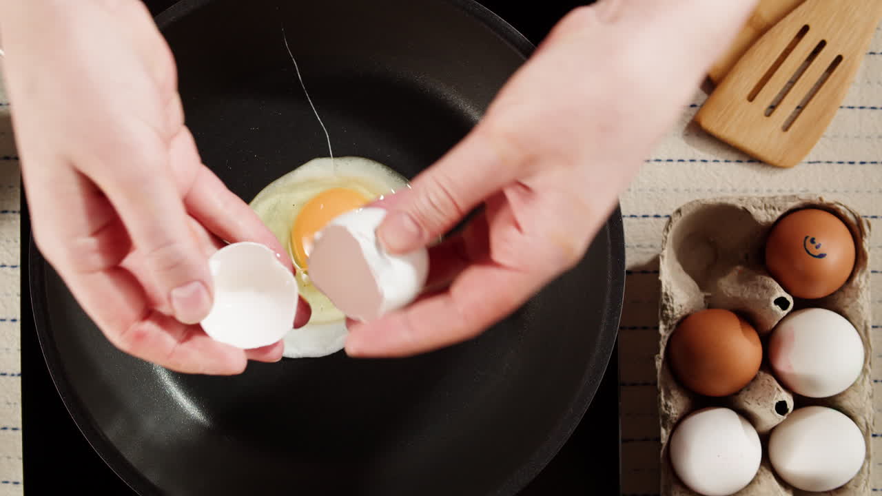 Cracking a Fresh Egg into a Frying Pan for Breakfast