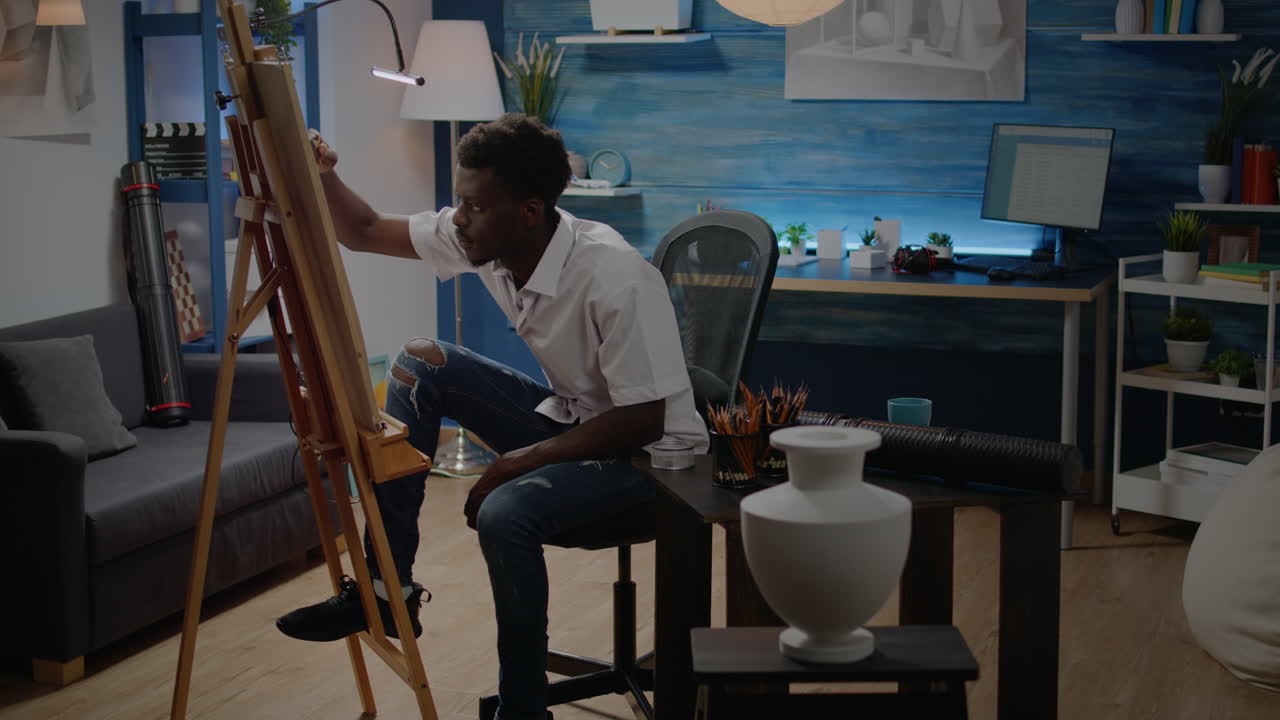 African american adult making fine art sitting in artwork studio