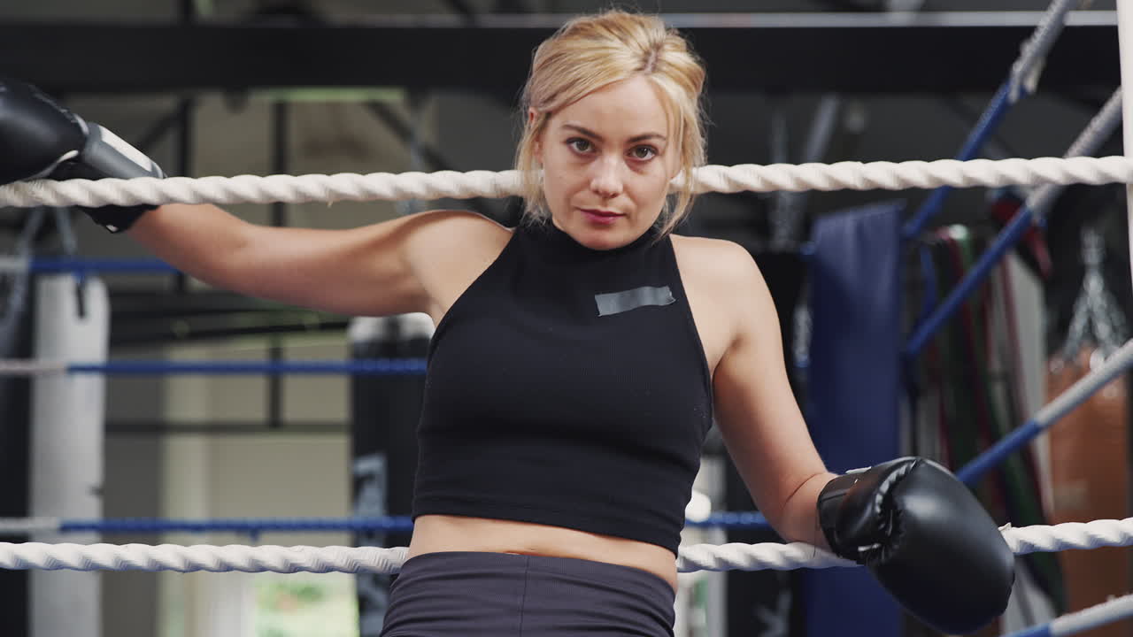 체육관 에서 권투 링 에 앉아 장갑 을 입은 여자 권투 선수 의 초상화