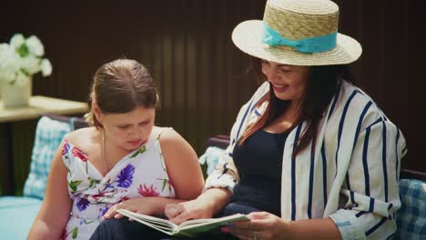 woman and girl reading together in a cozy outdoor setting with natural light and relaxed atmosphere