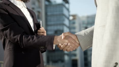 colleagues shaking hands on street