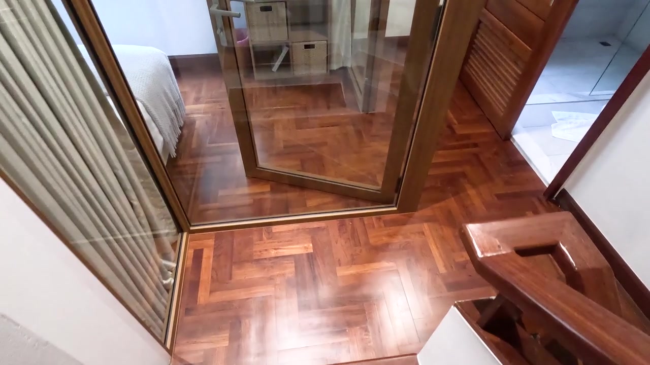 Camera moves down wooden stairs revealing herringbone hardwood floors and interior residential home design