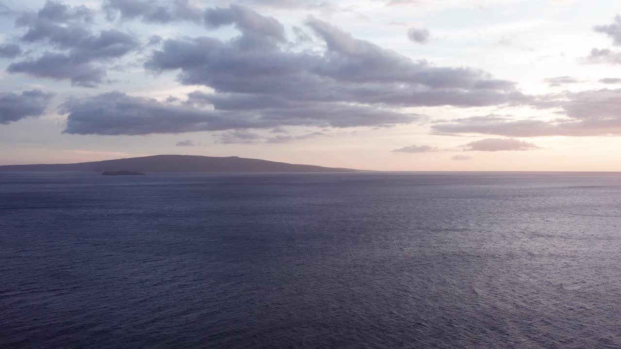 Aerial wide panning shot of the sacred island of Kaho'olawe and Molokini Crater at sunset from Wailea in West Maui, Hawai'i