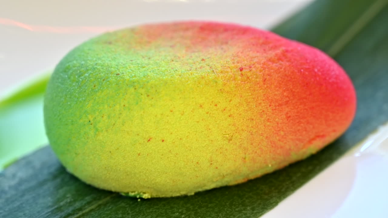 Close up of a mango-shaped dessert on a leaf