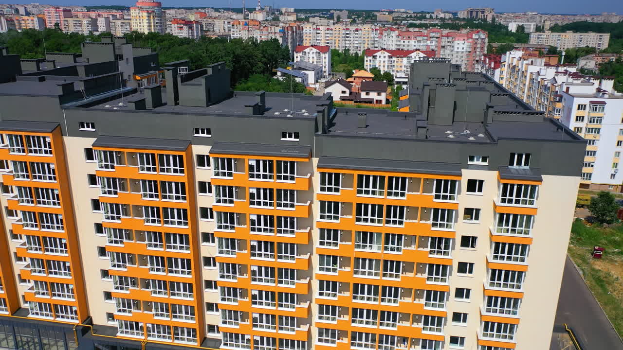 New city landmark. Modern apartment building on urban background. Colorful design of a multi-storey architecture. Aerial view.